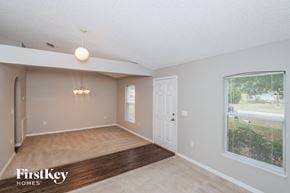 Palm Bay house for rent - A room with a wooden floor and a chandelier hanging from the ceiling.