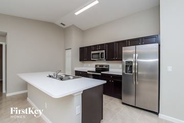 Palm Bay house for rent - A kitchen with a stainless steel refrigerator and a white island.