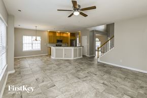 Charlotte house for rent - an empty kitchen and living room with a ceiling fan