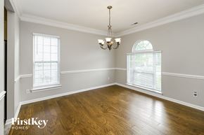 Charlotte house for rent - an empty dining room with wood floors and a chandelier