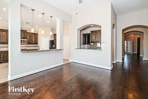 Garland house for rent - the living room and kitchen of a new home with hardwood floors and white walls