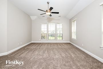 Garland house for rent - a spacious living room with carpet and a ceiling fan