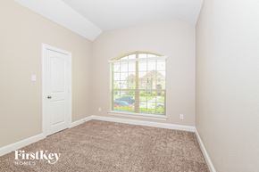 Garland house for rent - a bedroom with a large window and a door and carpet