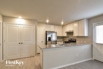 Converse house for rent - a kitchen with white cabinets and a counter top