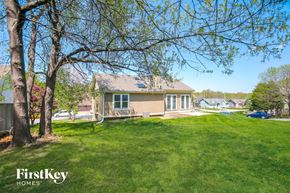 Kansas City house for rent - A house with a lawn and trees in front of it.