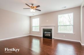 Concord house for rent - a empty living room with a ceiling fan and a fireplace