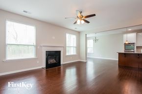 Concord house for rent - an empty living room with a fireplace and a ceiling fan