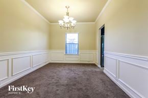 Braselton house for rent - a dining room with white wainscoting and a chandelier