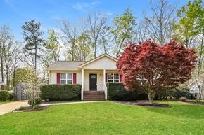Holly Springs house for rent - A house with a red door and a tree with red leaves in front.
