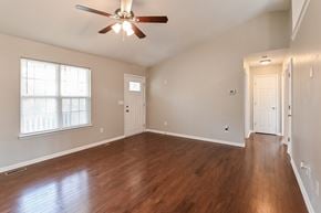 Holly Springs house for rent - A room with a ceiling fan and wooden floors.