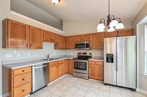 Holly Springs house for rent - A kitchen with wooden cabinets and stainless steel appliances.