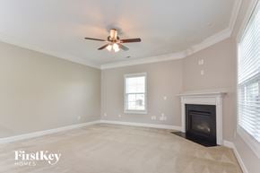 Whitsett house for rent - a living room with a fireplace and a ceiling fan