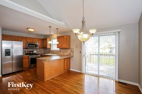 Raymore house for rent - an empty kitchen with a sliding glass door to the patio