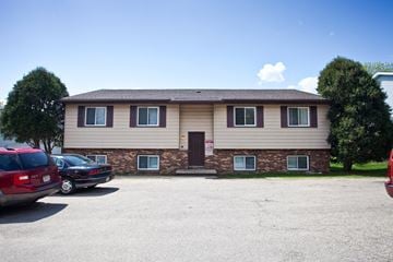 Madison apartment for rent - the front of a tan house with cars parked in a parking lot