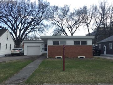 Grand Forks house for rent - the front of a house with a brick wall and a driveway