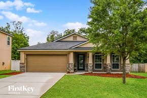 Jacksonville house for rent - A house with a brown garage door is for sale by FirstKey Homes.