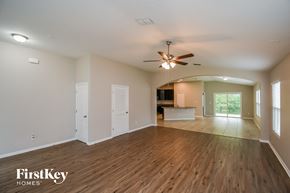 Jacksonville house for rent - A spacious room with wooden floors and a ceiling fan.