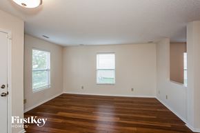 Noblesville house for rent - the living room of an empty house with wood floors and white walls
