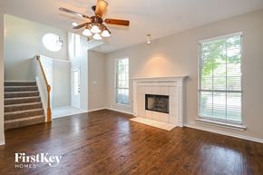 Carrollton house for rent - A spacious living room with a fireplace and a staircase.