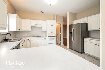 Carrollton house for rent - A kitchen with white cabinets and appliances.
