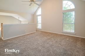 Carrollton house for rent - A spacious room with a fan and a window with blinds.