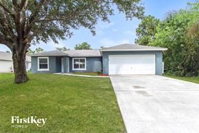 Palm Bay house for rent - a blue house with a white garage door and a lawn