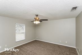 Palm Bay house for rent - a bedroom with a ceiling fan and a carpet
