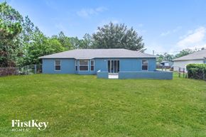 Palm Bay house for rent - a blue house with a grassy yard and a fence