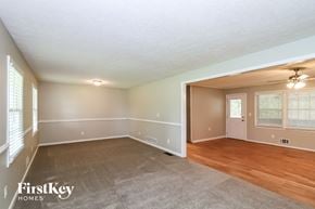 Kennesaw house for rent - the living room and dining room of a house with wood flooring and white walls