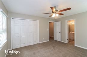Kennesaw house for rent - a bedroom with a ceiling fan and a door to a bathroom