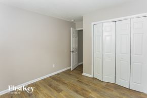 Charlotte house for rent - a bedroom with white closets and a hard wood floor