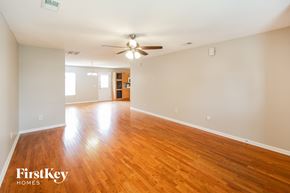 Summerville house for rent - A spacious room with wooden floors and a ceiling fan.