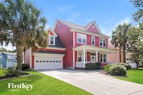 Summerville house for rent - a red house with a garage and palm trees