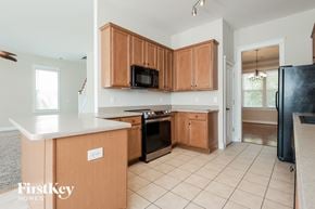 Summerville house for rent - a kitchen with wooden cabinets and a black stove and a microwave