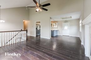 Raymore house for rent - a living room with a staircase and a ceiling fan