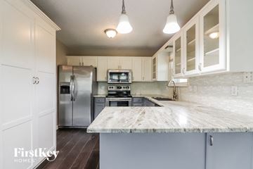 Raymore house for rent - a kitchen with a marble counter top and stainless steel appliances