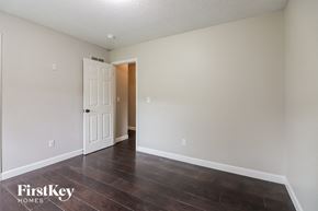 Raymore house for rent - a bedroom with white walls and wood floors and a white door