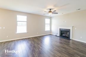 Summerville house for rent - A spacious living room with a fireplace and a ceiling fan.