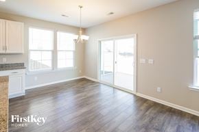 Summerville house for rent - A spacious room with wooden floors and a chandelier.