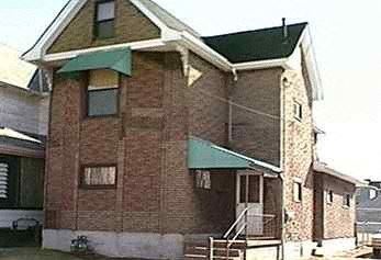 Mckeesport apartment for rent - an old brick house with a green roof and stairs