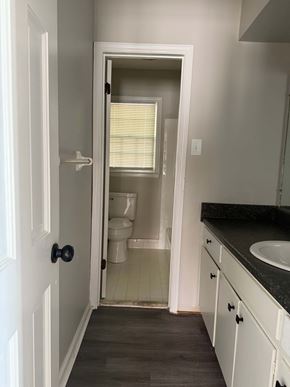 Albany apartment for rent - A bathroom with a toilet, sink, and mirror.