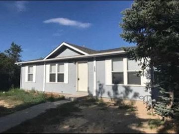 Pueblo house for rent - a small white house with a driveway and trees