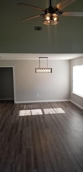 Leesburg house for rent - an empty living room with wood floors and a ceiling fan
