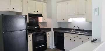 Leesburg house for rent - a kitchen with black appliances and white cabinets