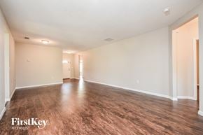 North Port house for rent - the living room and dining room of an empty house with wood flooring