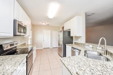 North Port house for rent - a kitchen with granite counter tops and stainless steel appliances