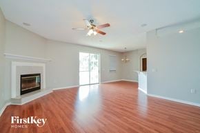 Winter Haven house for rent - an empty living room with a fireplace and a ceiling fan