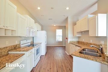 Winter Haven house for rent - a large kitchen with white cabinets and granite counter tops