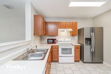 Haslet house for rent - A kitchen with wooden cabinets and stainless steel appliances.