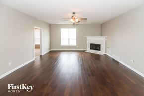 Arlington house for rent - A spacious room with wooden floors and a fireplace.